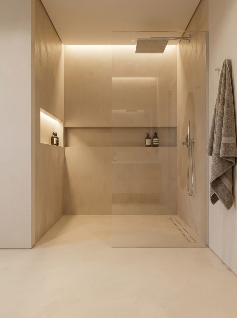Eine moderne, fugenlose Dusche in Betonoptik mit eleganter Wandgestaltung und minimalistischem Designboden.