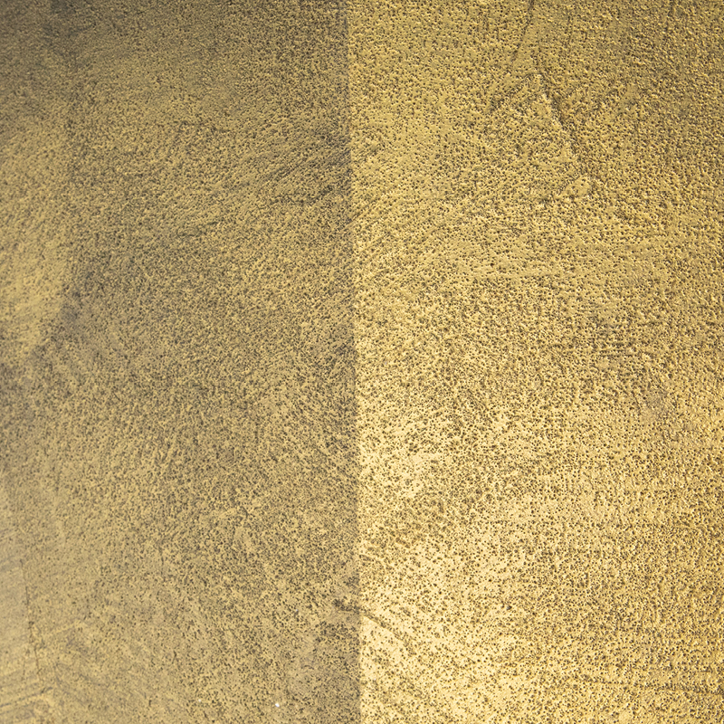 Ein goldfarbener Wandbelag in Betonoptik zeigt elegante Spachteltechnik für moderne Wandgestaltung im Badezimmer.
