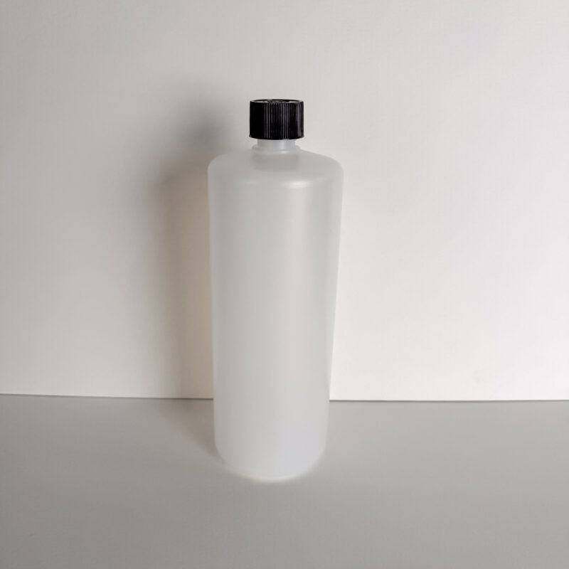 Die COLORIAMO-1000-ml-Rundflasche steht auf einer weißen Fläche und eignet sich für fugenlose Wandgestaltung.