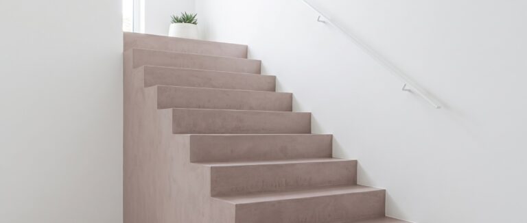 Fugenlose COLORIAMO-Betonoptik-Treppe mit elegantem Design und minimalistischer Wandgestaltung in hellen Tönen. | © COLORIAMO